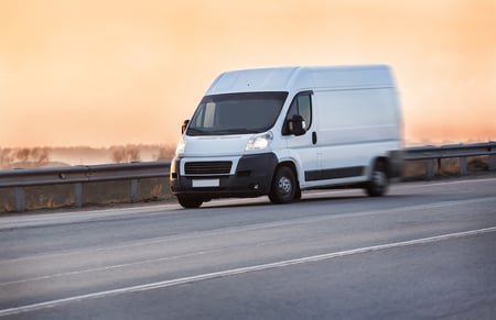 White Delivery Van Driving Down the Highway White Delivery Van Driving Down the Highway